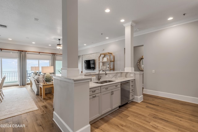 kitchen featuring ornate columns, dishwasher, kitchen peninsula, white cabinets, and light wood-type flooring