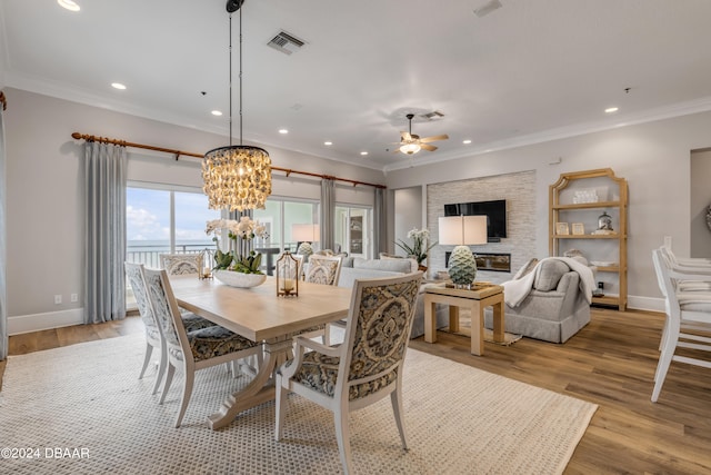 dining area featuring ceiling fan with notable chandelier, light wood-type flooring, and ornamental molding