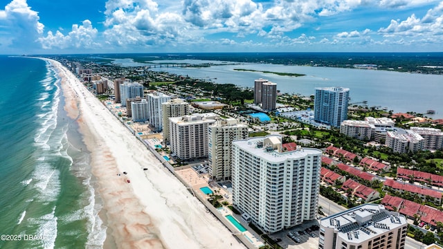 aerial view with a city view, a water view, and a beach view