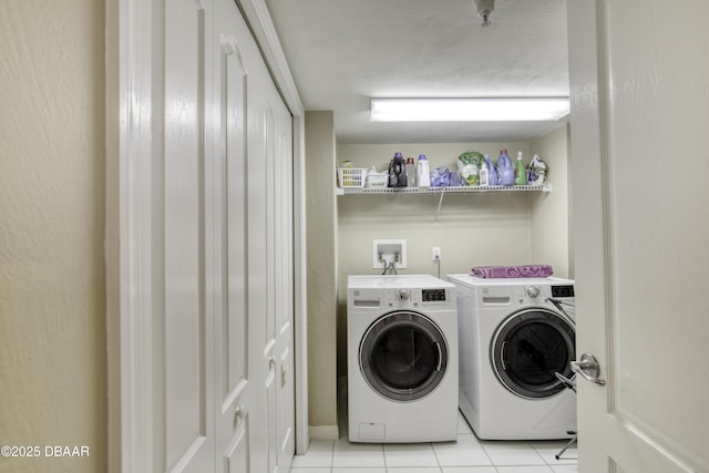 laundry area featuring laundry area, washer and clothes dryer, and light tile patterned flooring