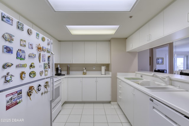 kitchen with a sink, white appliances, light countertops, and light tile patterned floors