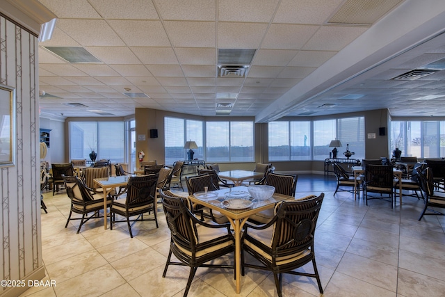 dining area featuring light tile patterned floors, visible vents, and a paneled ceiling