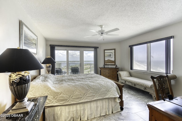 bedroom featuring ceiling fan, a textured ceiling, and access to exterior