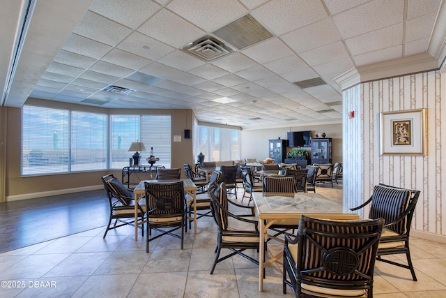 dining space with light tile patterned floors, visible vents, baseboards, and a paneled ceiling