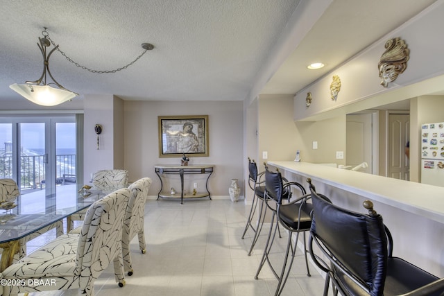 dining room featuring baseboards, recessed lighting, light tile patterned flooring, and a textured ceiling