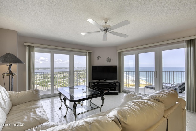 living room featuring a wealth of natural light, a ceiling fan, and light tile patterned floors