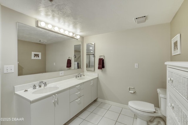 full bath with a sink, tile patterned flooring, toilet, and double vanity