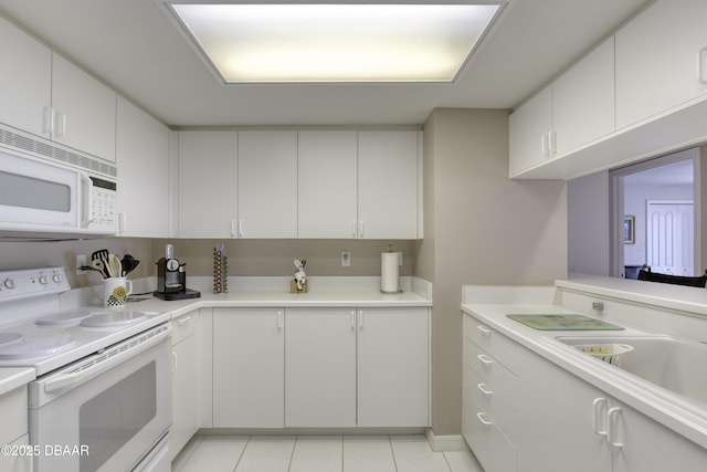 kitchen featuring light tile patterned floors, white appliances, light countertops, and a sink