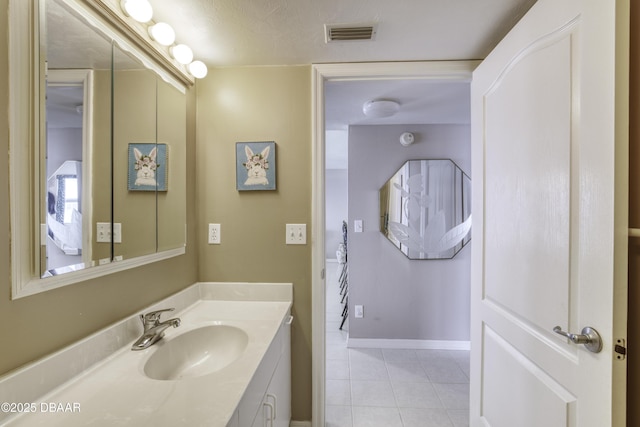 bathroom featuring vanity, baseboards, visible vents, and tile patterned floors