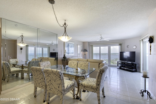 dining space with a textured ceiling, a ceiling fan, and light tile patterned floors