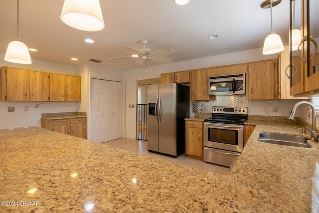 kitchen featuring stainless steel appliances, hanging light fixtures, sink, light tile patterned floors, and ceiling fan