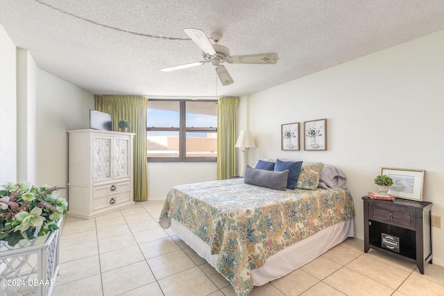 bedroom with ceiling fan, a textured ceiling, and light tile patterned floors