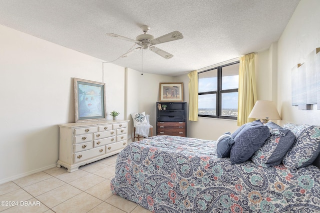 bedroom with ceiling fan, a textured ceiling, and light tile patterned floors