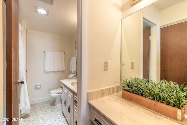 bathroom featuring toilet, vanity, and tile patterned flooring