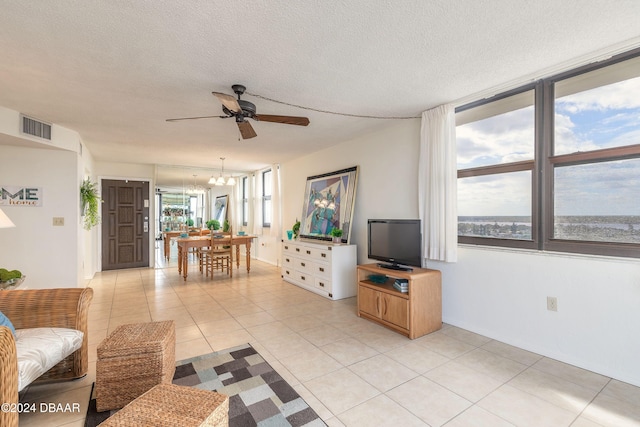 1415 Ocean Shore Blvd Unit 1111, Ormond Beach, FL 32176 - living room featuring a ceiling fan, a chandelier, light tile patterned floors, and a textured ceiling