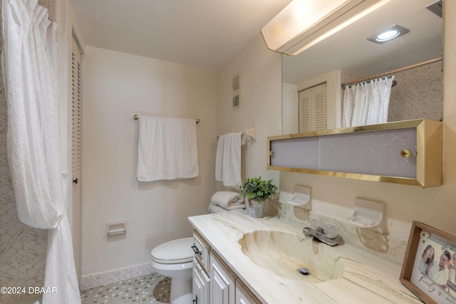 bathroom with toilet, vanity, and tile patterned flooring