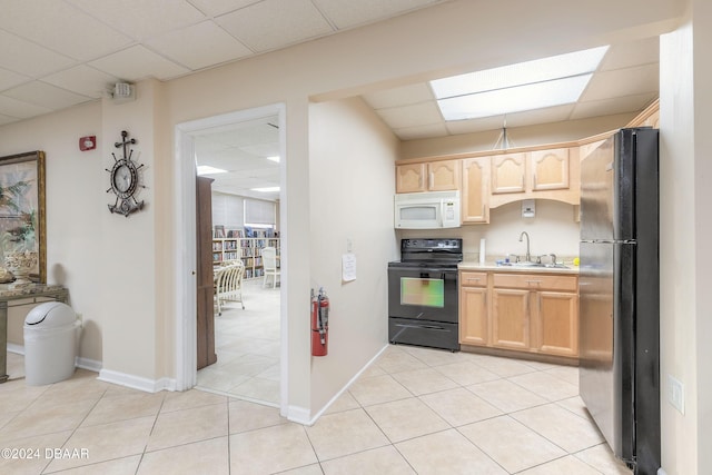 kitchen with sink, a drop ceiling, light brown cabinets, and black appliances