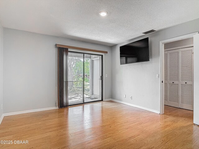 1104 Monticello Ln Unit 4, Port Orange, FL 32129 - unfurnished room with baseboards, a textured ceiling, visible vents, and light wood-style flooring