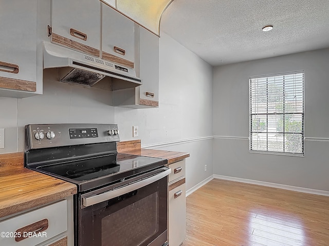 1104 Monticello Ln Unit 4, Port Orange, FL 32129 - kitchen featuring light wood-style floors, baseboards, stainless steel electric stove, under cabinet range hood, and butcher block countertops