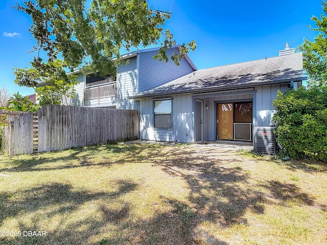 1104 Monticello Ln Unit 4, Port Orange, FL 32129 - rear view of property featuring fence, roof with shingles, a chimney, board and batten siding, and central air condition unit