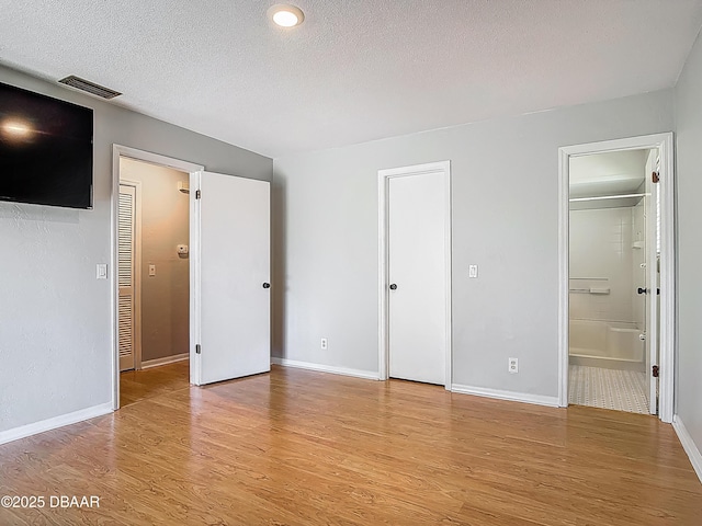 1104 Monticello Ln Unit 4, Port Orange, FL 32129 - unfurnished bedroom with baseboards, light wood finished floors, a textured ceiling, and visible vents