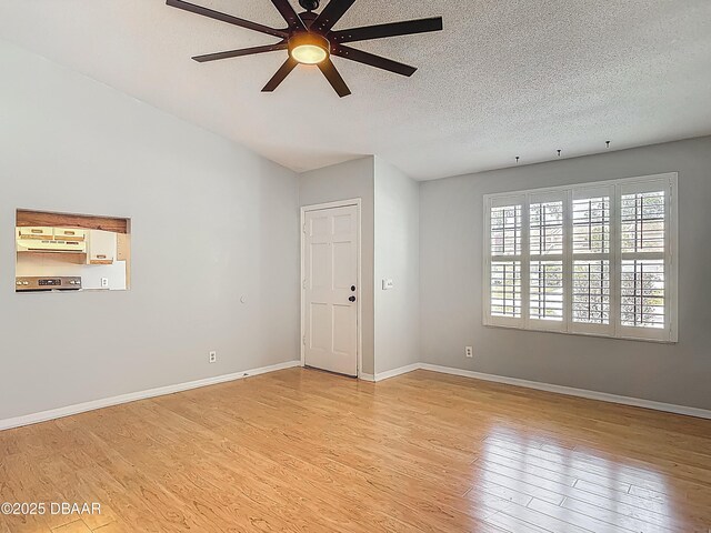 1104 Monticello Ln Unit 4, Port Orange, FL 32129 - empty room featuring a textured ceiling, ceiling fan, baseboards, and light wood-type flooring