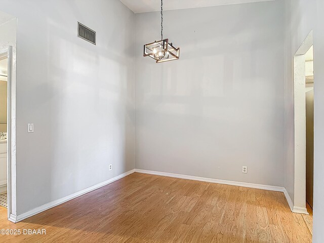 1104 Monticello Ln Unit 4, Port Orange, FL 32129 - unfurnished dining area featuring light wood-style floors, baseboards, a notable chandelier, and visible vents