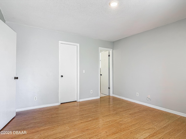 1104 Monticello Ln Unit 4, Port Orange, FL 32129 - unfurnished room featuring baseboards, a textured ceiling, and wood finished floors