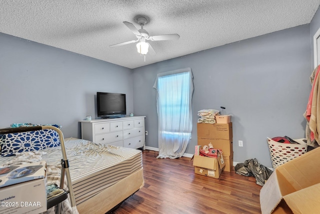 bedroom featuring ceiling fan, baseboards, wood finished floors, and a textured ceiling