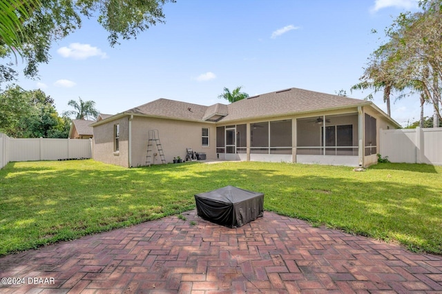 rear view of house featuring a sunroom, a yard, and a patio area