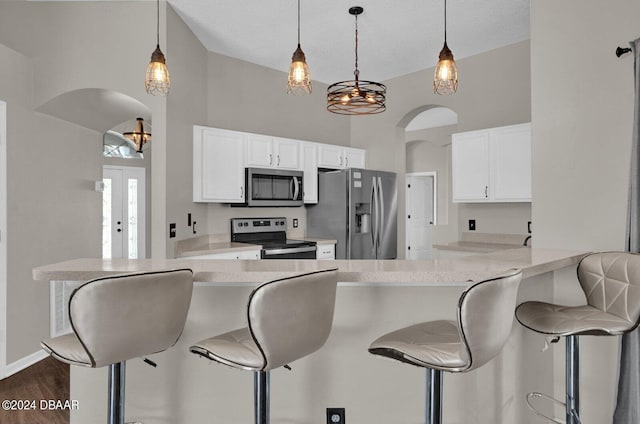 kitchen with kitchen peninsula, appliances with stainless steel finishes, and white cabinets