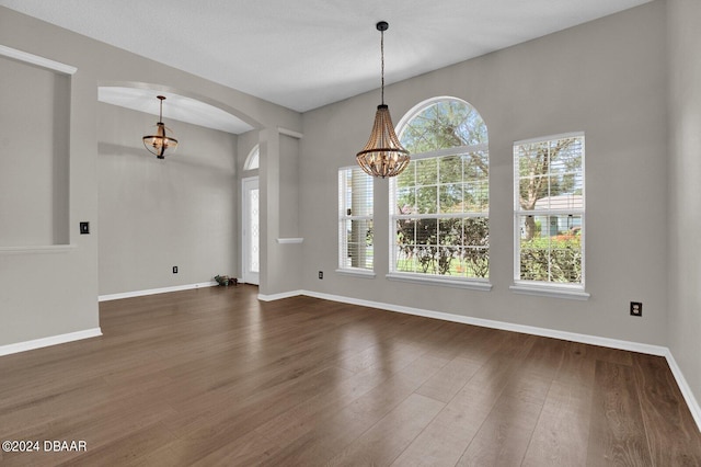 interior space with dark wood-type flooring and a notable chandelier