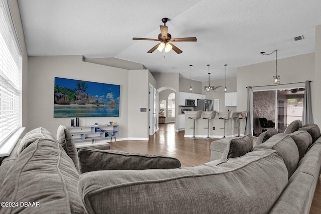 living room featuring lofted ceiling, hardwood / wood-style floors, ceiling fan, and plenty of natural light