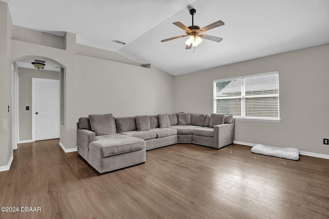 living room featuring wood-type flooring, a textured ceiling, ceiling fan, and vaulted ceiling