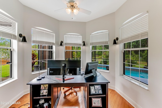 office with a ceiling fan, light wood-type flooring, and baseboards