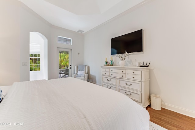 bedroom with visible vents, baseboards, arched walkways, and wood finished floors