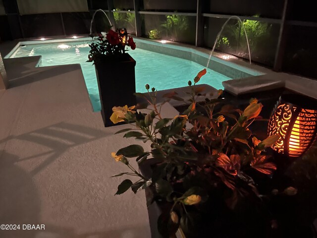 view of swimming pool featuring pool water feature, ceiling fan, a lanai, and a patio area