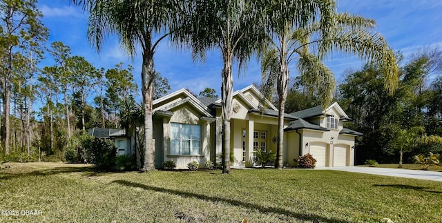 view of front of property featuring a garage, stucco siding, concrete driveway, and a front yard