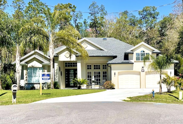 view of front of home featuring driveway, a shingled roof, stucco siding, a front lawn, and a garage