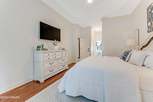 bedroom with visible vents, wood finished floors, and baseboards