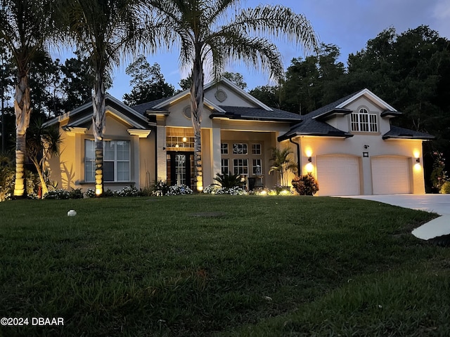 view of front of home featuring a garage, a yard, and french doors