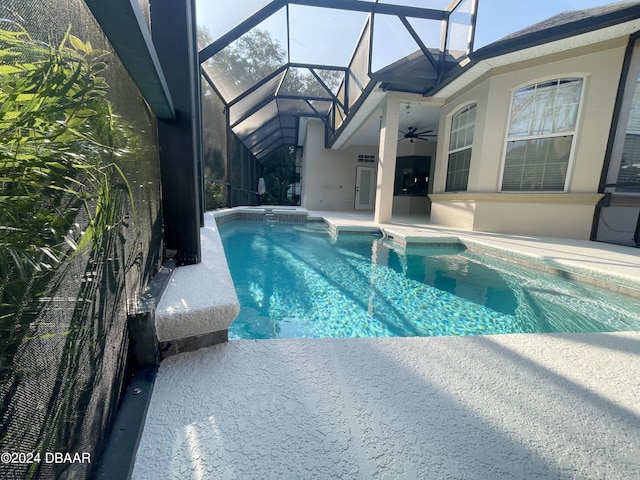 view of pool with glass enclosure, ceiling fan, and a patio area