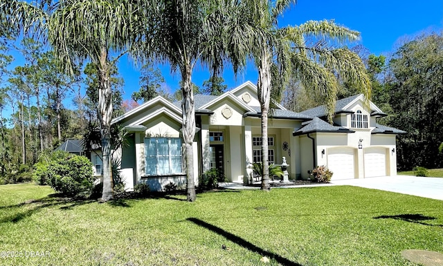 view of front of home with stucco siding, a garage, concrete driveway, and a front lawn