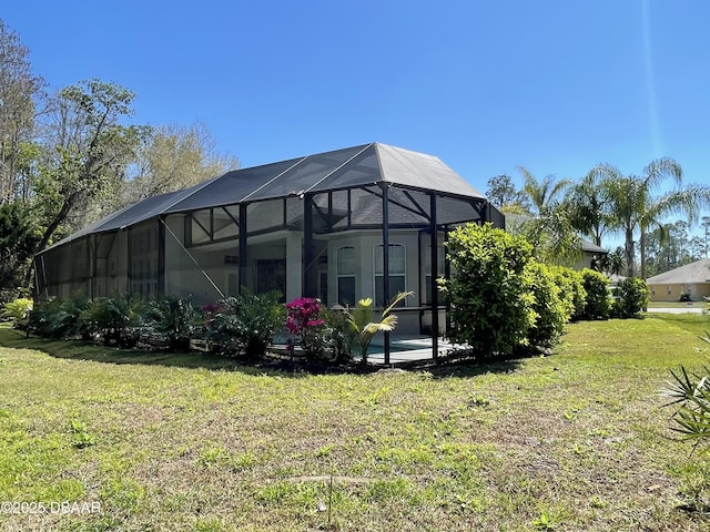 back of house featuring a lawn and glass enclosure