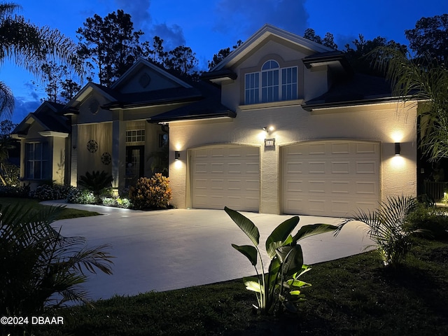 view of front of property with concrete driveway, a garage, and stucco siding