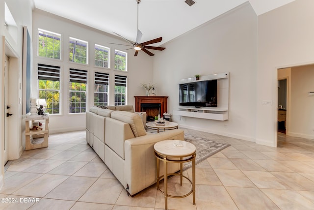 living room featuring a high ceiling, light tile patterned floors, and baseboards