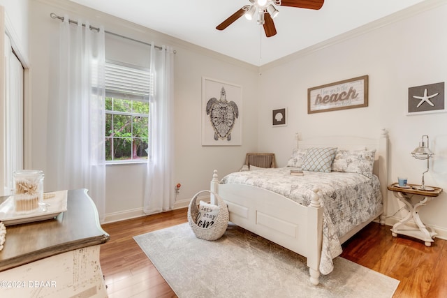 bedroom featuring baseboards, a ceiling fan, light wood-style floors, and ornamental molding