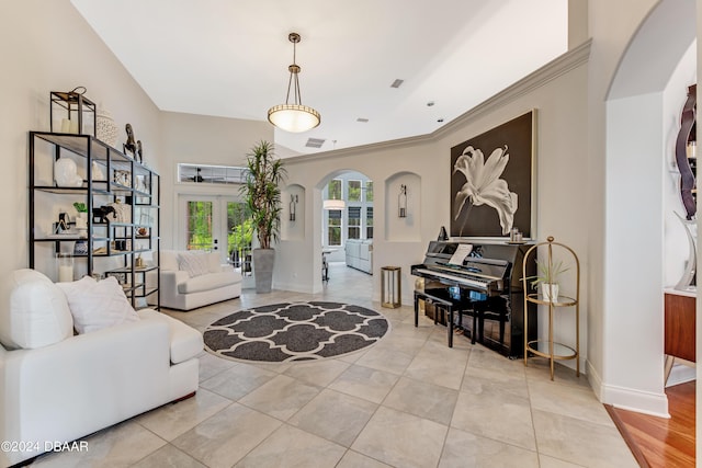 entryway with tile patterned flooring, crown molding, baseboards, and arched walkways