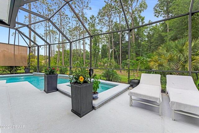 view of swimming pool featuring pool water feature, ceiling fan, a lanai, and a patio area