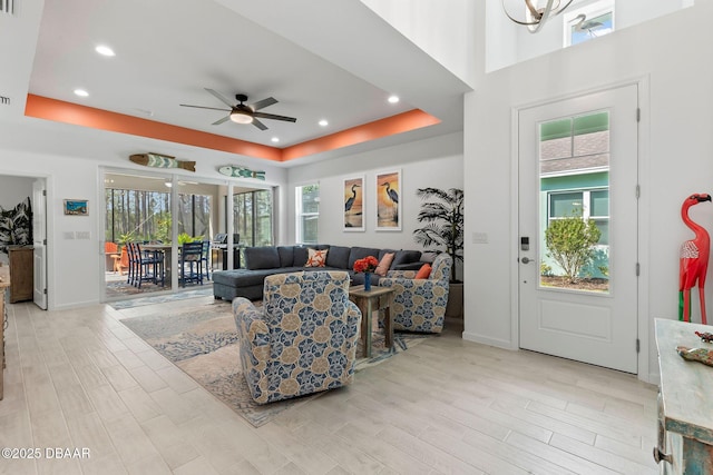 living room featuring a raised ceiling and a healthy amount of sunlight